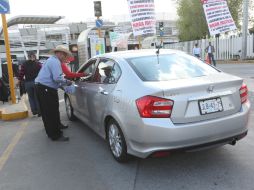 Cerca de 30 personas se han desplegado en el estacionamiento para pedir una cuota voluntaria de cinco a 30 pesos. EL INFORMADOR / G. Gallo