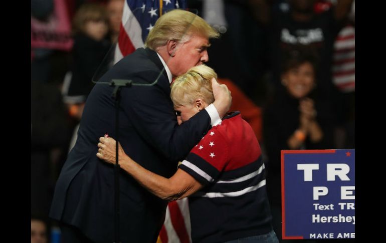 Donald Trump reconforta a una simpatizante durante un mitin en Hershey, Pensilvania. AFP / S. Platt