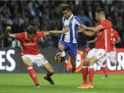 Corona, del Porto, salta entre dos jugadores del Benfica. AP / P. Duarte