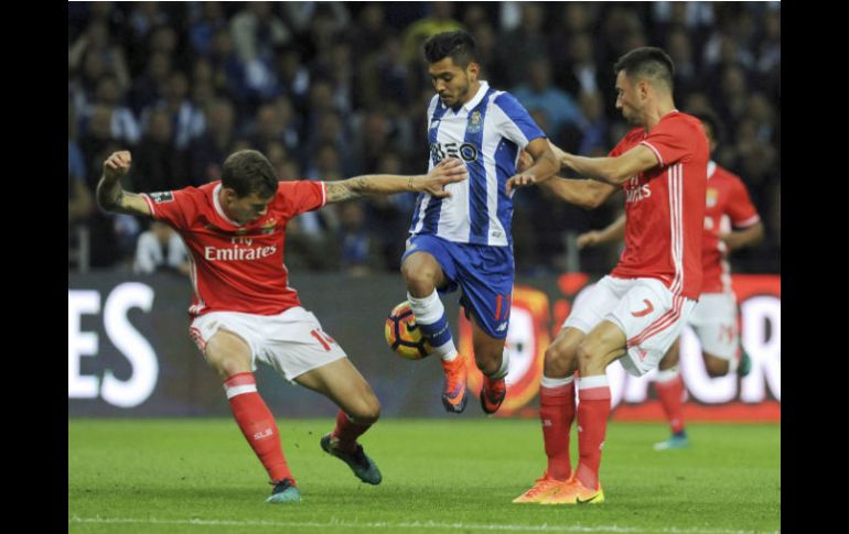 Corona, del Porto, salta entre dos jugadores del Benfica. AP / P. Duarte