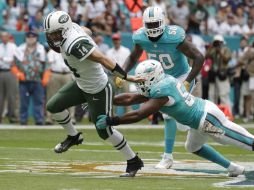 Fitzpatrick (I), quarterback de Nueva York, escapa de una tacleada de Jenkins, de Miami. AP / L. Sladky