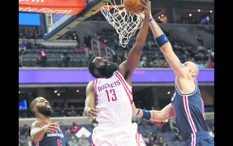 James Harden. El jugador de los Rockets (al centro) trata de encestar el balón. AP /