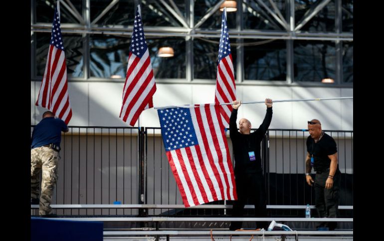 Trabajadores montan las banderas en el Javits Center, donde Clinton aplaudiría su victoria de ser ella quien gane las elecciones. AFP / D. Angerer