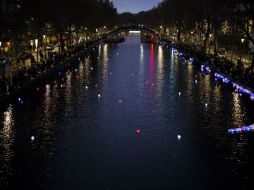 Franceses colocan linternas flotantes en el Canal de San Martín, en París, para honrar a las 130 víctimas de los ataques. AP / K. Zihnioglu