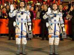 Jian Haipeng y Chen Dong saludan al público tras concluir con éxito su misión espacial de acoplar el laboratorio Tiangong-2. ESPECIAL /