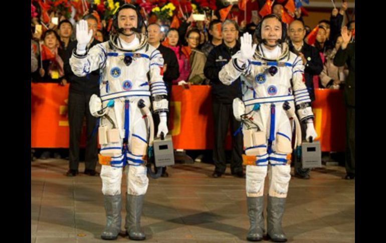 Jian Haipeng y Chen Dong saludan al público tras concluir con éxito su misión espacial de acoplar el laboratorio Tiangong-2. ESPECIAL /