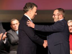 El presidente y el líder guerrillero, Juan Manuel Santos y Rodrigo Londoño, sellan el fin del conflicto armado. EFE / M. Dueñas