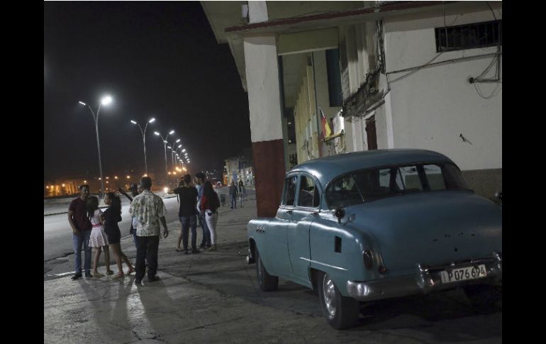 Varios turistas conversan en el malecón de La Habana, que luce vacío. EFE / A. Ernesto