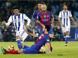 Busquets, del Barcelona, se barre para detener al mexicano. EFE / J. Herrero