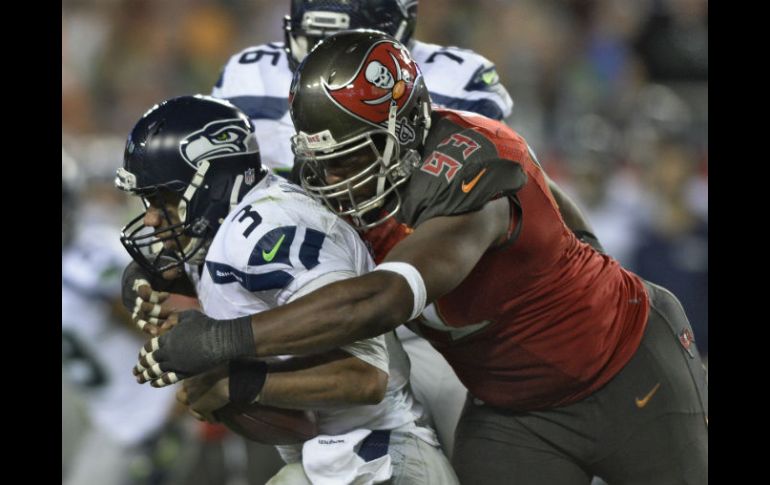 McCoy (D), de los Bucaneros, taclea al mariscal de campo de los Halcones Marinos, Russel Willson (I). AP / J. Benkhen