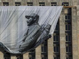 Un hombre despliega una imagen gigante del ex presidente de Cuba, durante los preparativos de su funeral. AP / D. Boylan