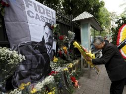 Ciudadanos depositan flores ante la fotografía del líder cubano Fidel Castro. EFE / L. Thai