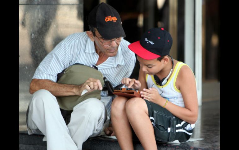 El uso de tabletas y celulares nos obliga a bajar la mirada como si estuviéramos ante un libro. EFE / ARCHIVO