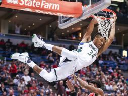 Giannis Antetokounmpo clava el balón ante la marca de Rajon Rondo, durante el partido de ayer. EFE / T. Maury