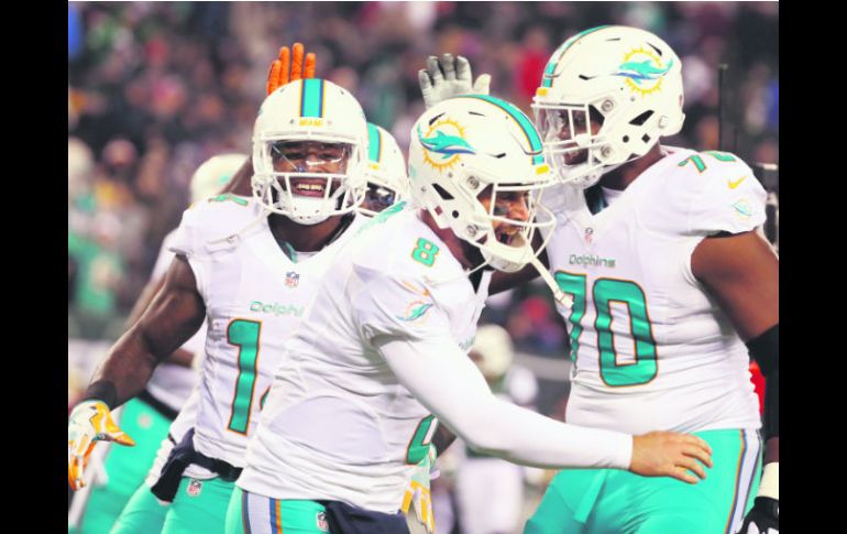 En su primer juego como titular en cinco años con los Dolphins, Matt Moore (#8) logró cuatro pases de anotación frente a los Jets. AFP / A. Bello