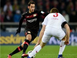 Calhanouglu (I) de Leverkusen, disputa un balón con Heintz (D), de Colonia. EFE / J. Guetter