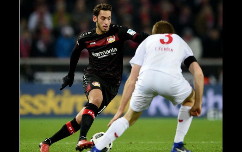 Calhanouglu (I) de Leverkusen, disputa un balón con Heintz (D), de Colonia. EFE / J. Guetter