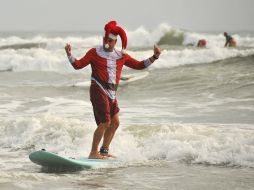 Decenas de surfistas ataviados en disfraces de Santa Claus participaron en el concurso. AP / M. Denemark