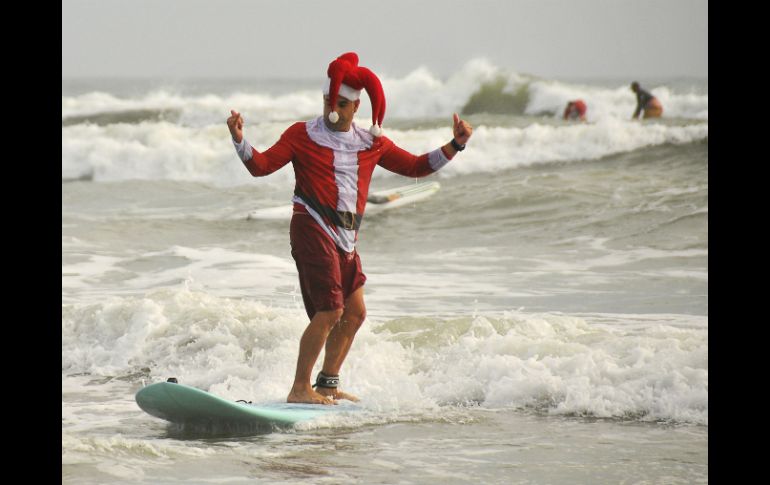 Decenas de surfistas ataviados en disfraces de Santa Claus participaron en el concurso. AP / M. Denemark