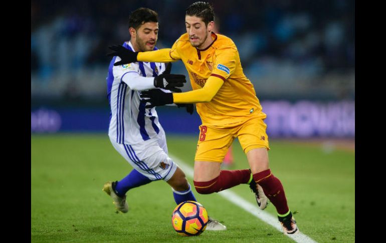 Vela (I) disputa un balón con Escudero (D), del Sevilla. AFP / M. Riopa