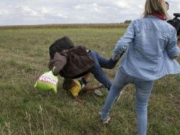 ) La camarógrafa húngara fue captada en video cuando pateaba a migrantes junto a la frontera del país con Serbia. TWITTER / @canlihaberleri