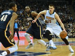 Nikola Jokic (#15), de los Nuggets, avanza con la pelota frente a Al Jefferson (#7) y Glenn Robinson (#40) de Indiana. AFP / G. Kirk