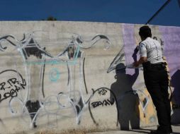 Muchas áreas han sido pintadas con grafitis de los pandilleros, pero con apoyo de vecinos están repintando paredes, muros y casas. AFP / J. Ordonez