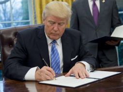 El presidente Trump firma la orden ejecutiva para sacar a Estados Unidos del Acuerdo Transpacífico de Cooperación Económica. AFP / S. Loeb