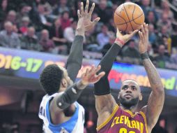 El astro LeBron James realiza un tiro para anotar dos de los 27 puntos que consiguió en su cuenta personal durante el partido de ayer. AP / T. Dejak