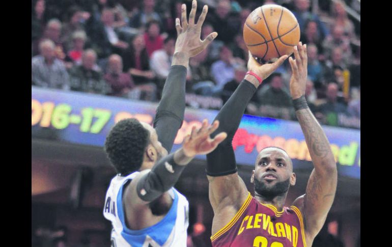 El astro LeBron James realiza un tiro para anotar dos de los 27 puntos que consiguió en su cuenta personal durante el partido de ayer. AP / T. Dejak