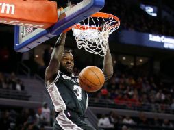 Dewayne Dedmon, de los Spurs, clava el balón ante la mirada de Andre Drummond, de los Pistons. AFP /  G. Shamus