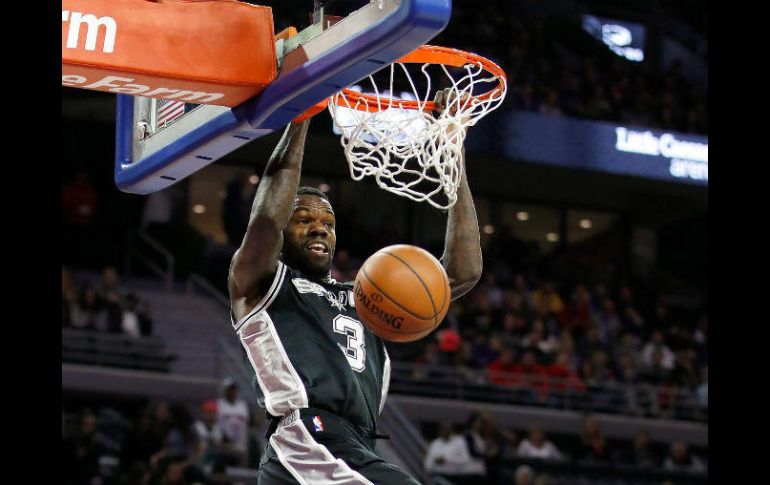 Dewayne Dedmon, de los Spurs, clava el balón ante la mirada de Andre Drummond, de los Pistons. AFP /  G. Shamus