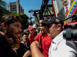 Periodistas y simpatizantes de Maduro se encaran frente al edificio de la Comisión Nacional de Telecomunicaciones. AFP / J. Barreto