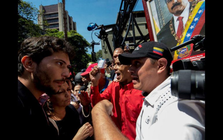 Periodistas y simpatizantes de Maduro se encaran frente al edificio de la Comisión Nacional de Telecomunicaciones. AFP / J. Barreto