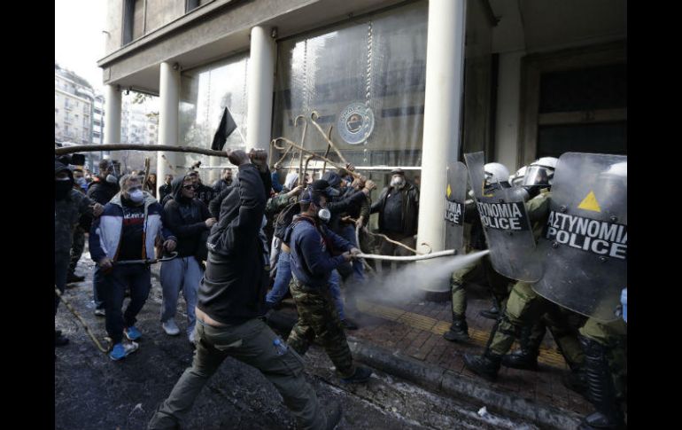 Los agricultores prendieron fuego a contenedores de basura y lanzaron piedras contra el edificio y contra las fuerzas antidisturbios. AP / T. Stavrakis