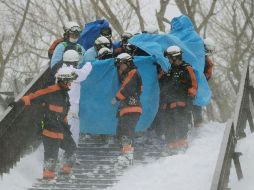 Rescatistas trasladan a un hospital a uno de los sobrevivientes del accidente. AFP / JIJI PRESS