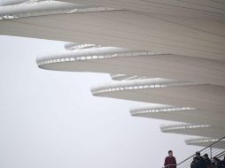 Un asistente observa el cielo cubierto desde uno de los asientos del circuito de Shanghái. AFP / J. Eisele