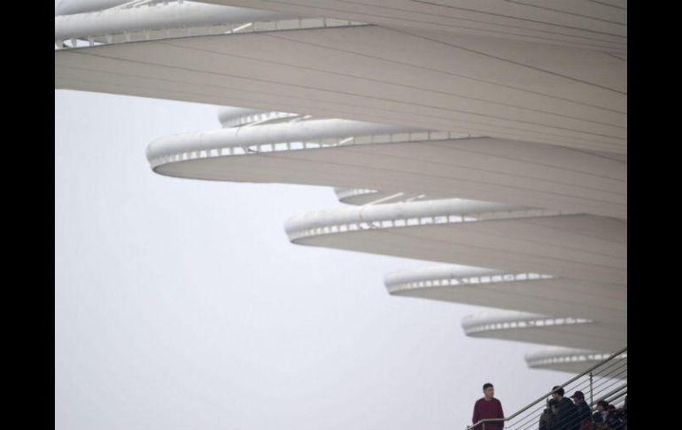 Un asistente observa el cielo cubierto desde uno de los asientos del circuito de Shanghái. AFP / J. Eisele