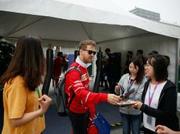 Vettel hace una pausa para dar autógrafos a varias admiradoras. EFE / R. Pilipey