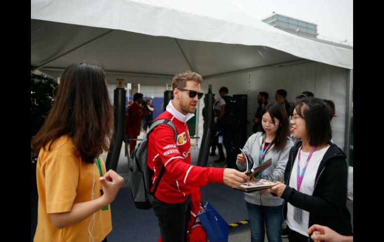 Vettel hace una pausa para dar autógrafos a varias admiradoras. EFE / R. Pilipey