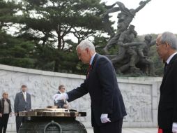 Pence, acompañado por su esposa y dos de sus hijas, deposita una corona en el Cementerio Nacional de Seúl en el inicio de su viaje. EFE / C. Sung-Jun