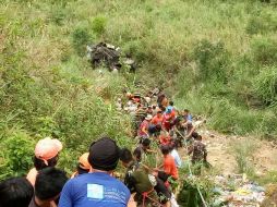 Imagen donde se ve a ciudadanos filipinos, soldados y policías sosteniendo una cuerda para recuperar los cuerpos de las víctimas. EFE / POLICÍA DE CARRANGLAN