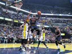 Imparable. LeBron James se eleva para encestar dos de los 33 puntos que consiguió ayer en el cuarto juego ante los Pacers. AP / D. Cummings