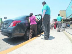 Una mujer que hizo sus compras en el supermercado ubicado en Patria y Ávila Camacho se sube a uno de los taxis ilegales. EL INFORMADOR / A. Camacho