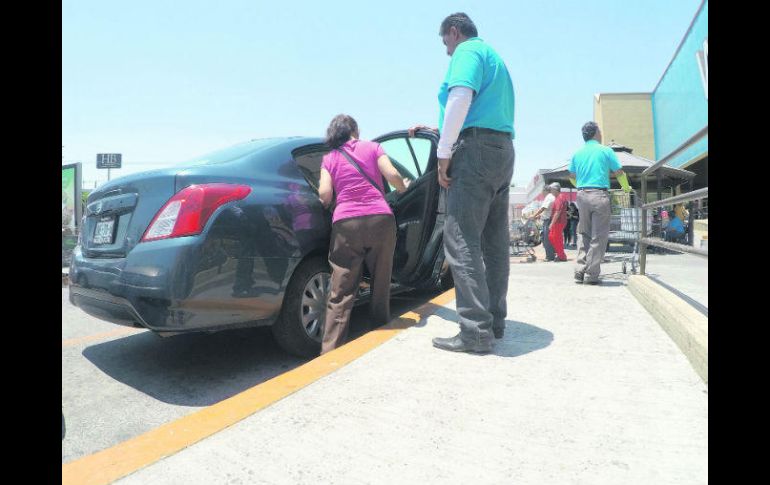 Una mujer que hizo sus compras en el supermercado ubicado en Patria y Ávila Camacho se sube a uno de los taxis ilegales. EL INFORMADOR / A. Camacho