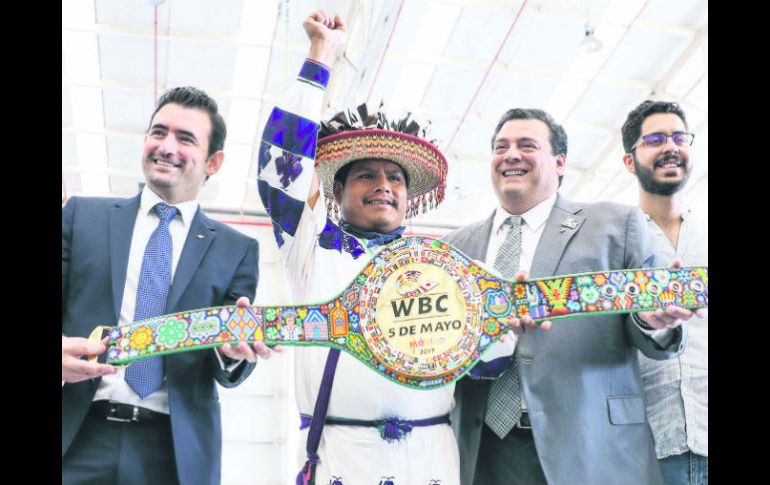 Luis de la Cruz y Mauricio Sulaimán (c) presumen el cinturón que se llevará el ganador de la pelea. SUN /