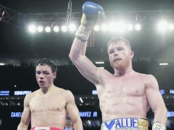 Visiblemente maltratado del rostro, Julio César Chávez Jr. observa a Saúl “Canelo” Álvarez festejar su victoria ayer en Las Vegas. AP /