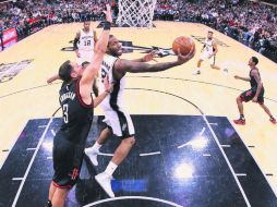 En duda. Kawhi Leonard (con el balón) sumó 22 puntos y 15 rebotes para los Spurs, pero salió lesionado del juego de ayer. AFP /