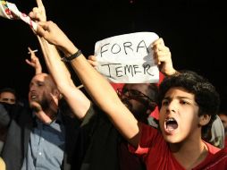 Manifestantes a las afueras del Palacio del Planalto con un cartelón que reza 'Fuera Temer'. AFP / E. Sa