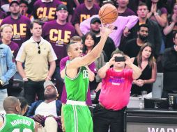 Avery Bradley (c), realiza un disparo desde el perímetro que terminó por encestarse y que le significó el primer triunfo para Celtics. AFP / J. Sabau